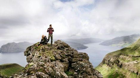 View of two people on top of a mountain in the Faroe Islands