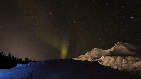 Faint views of the Northern Lights in Iceland, with snow drifts in the foreground